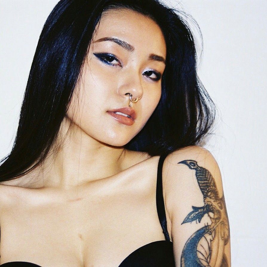 rae lil black sexy tatouage et septum regarde la caméra