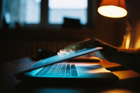 Homme fermant son ordinateur portable le soir, symbole de la décision d'arrêter le porno